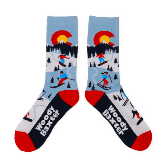 Pair of Adult CO Alpine Socks with a Colorado C above a snowy mountain scene with skiers and trees, with red toes and black feet.
